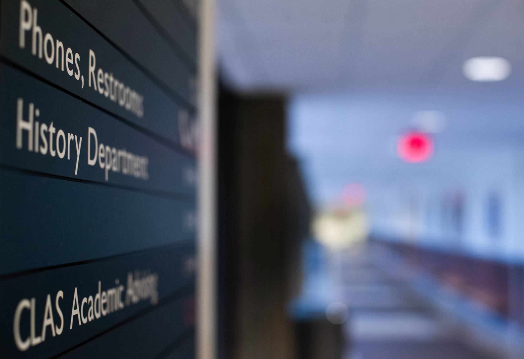 Hallway sign for CLAS Academic Advising Center in focus and the rest of the hallway out of focus